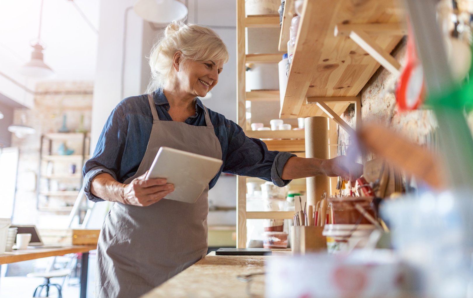 Senior Handwerkerin arbeitet im Kunststudio und verdient zur Rente dazu