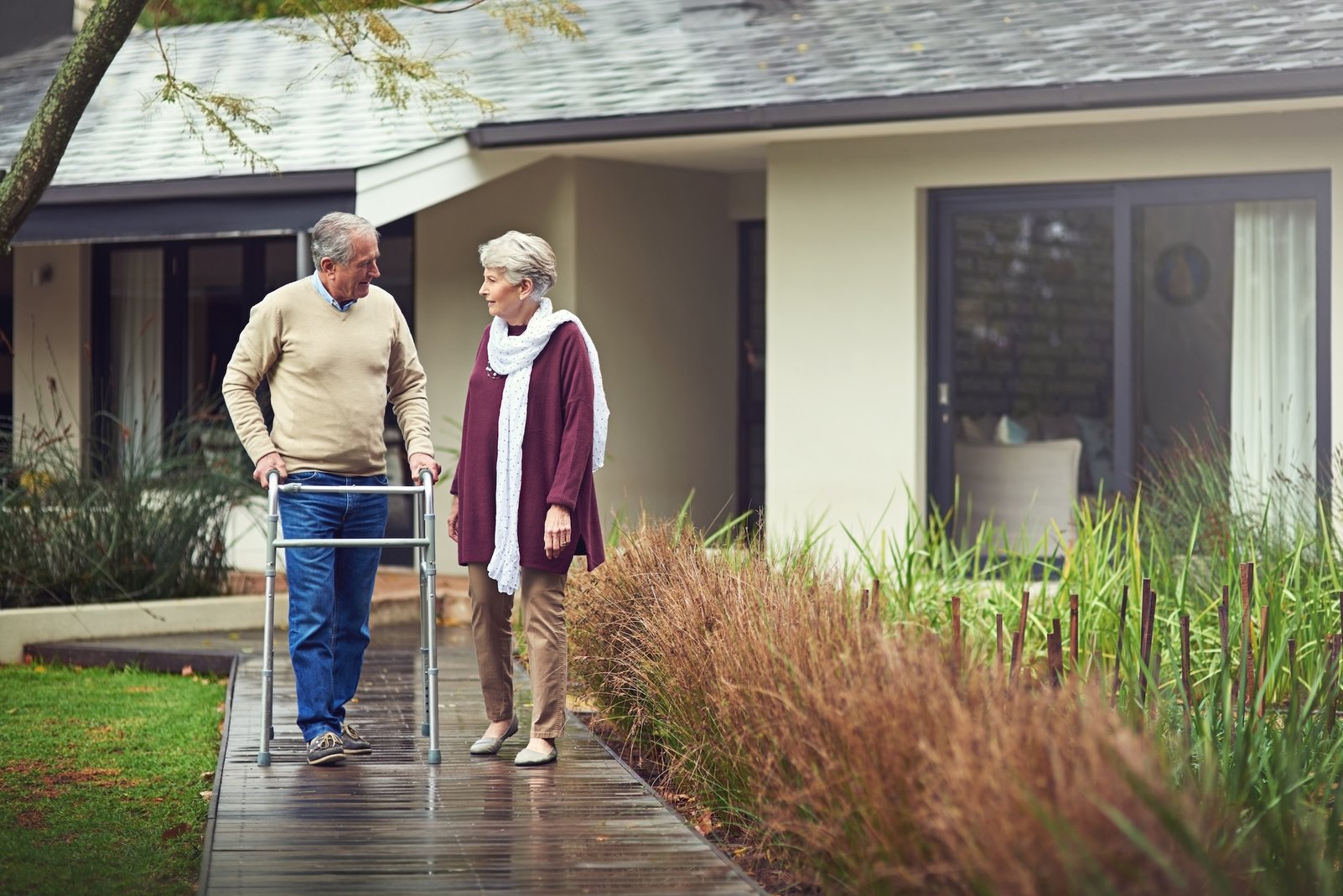 Paar nutzt Hilfsmittel für Senioren wie Rollator im eingenen Garten