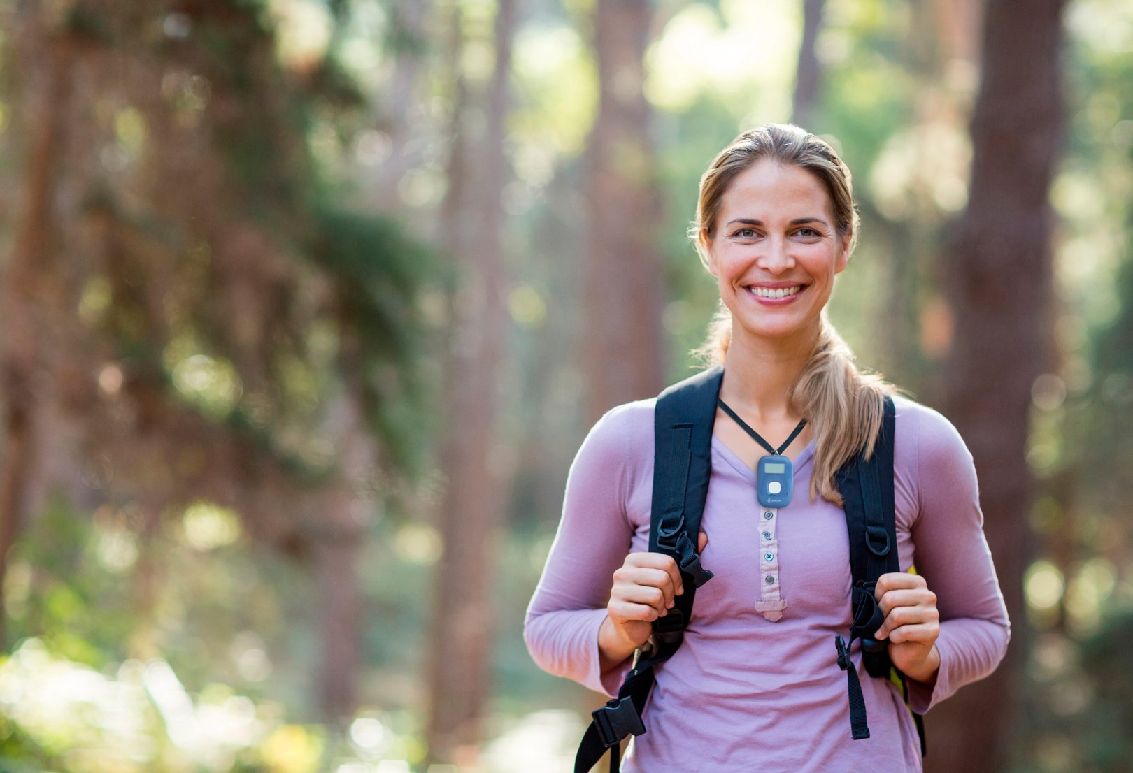 Aktive Frau ist mit ihrerm mobilen Hausnoturf mit GPS und ihrer Trekking-Ausrüstung unterwegs