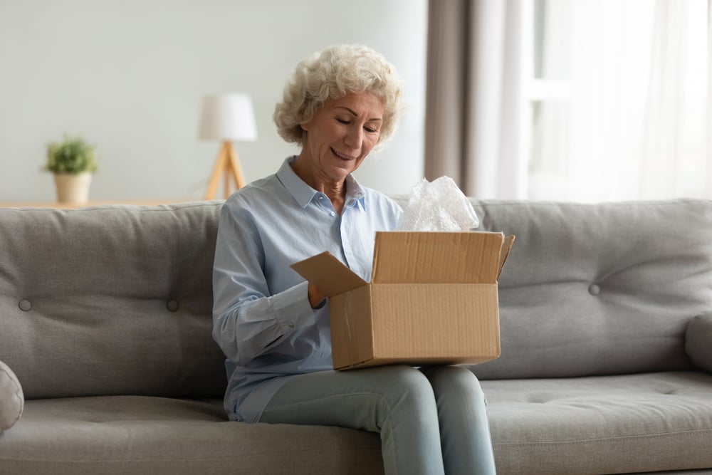 Ältere Frau erhält Pflegebox