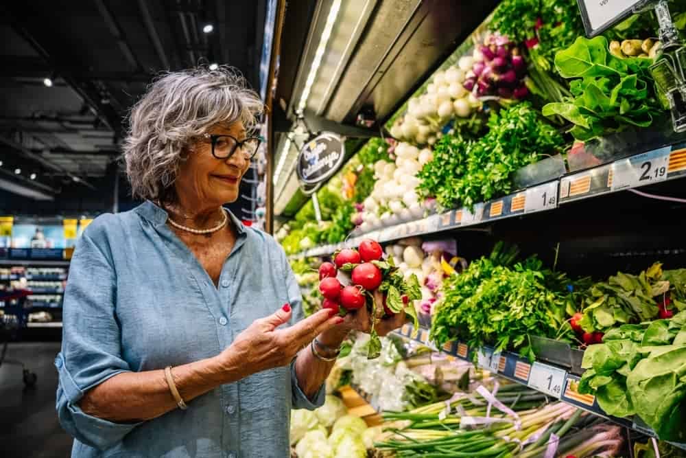 Seniorin sucht nach Lebensmittel im Supermarkt für die optimale Ernährung bei Rheuma